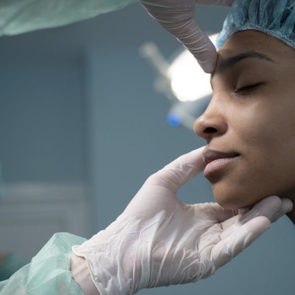 side-view-doctor-checking-patient-before-rhinoplasty-min